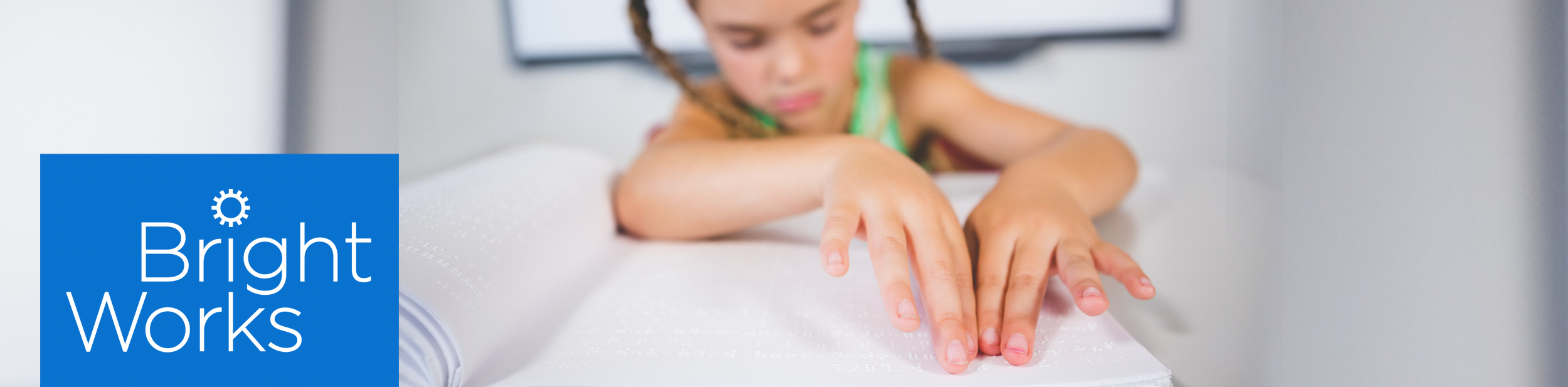 Schoolgirl reading a braille book in classroom stock photo